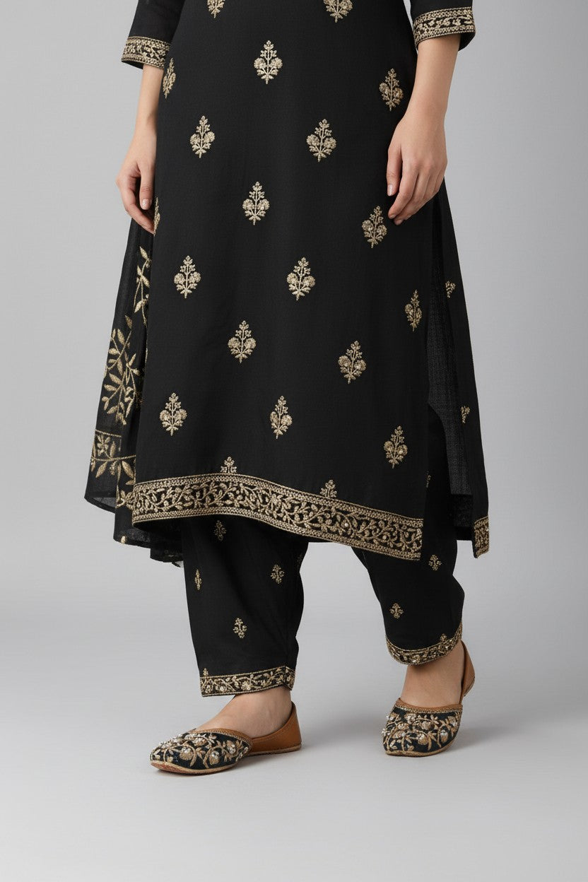 My Store 2 black juttis featuring intricate gold floral embroidery and pearl embellishments worn with a matching outfit
