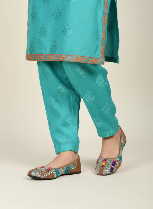 My Store 2 embellished tan flats with turquoise stones, crystals, and beads worn with teal embroidered trousers.
