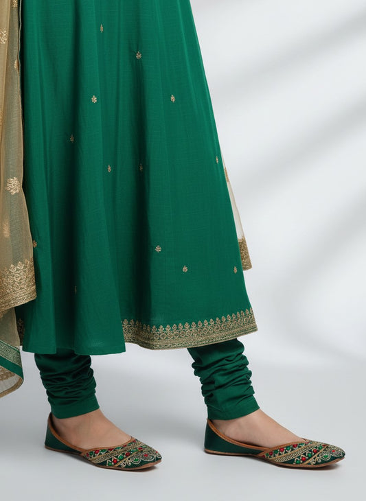My Store 2 traditional green juttis featuring intricate multi-colored embroidery and gold detailing on a flat sole.