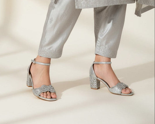  silver glitter block heel sandals with crystal embellishments worn with a matching embroidered silver outfit